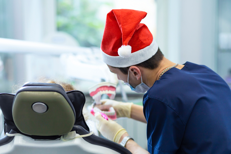 Female child at dentist on Christmas holidays. children’s dentistry. examination of teeth. girl at doctor for new year in Santa hat. oral hygiene training.