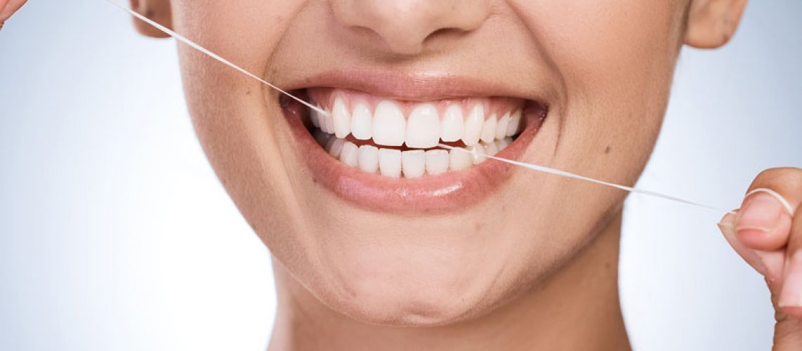 2024-08-Cos2-Woman-mouth-and-floss-teeth-in-studio-orthodontics-and-cosmetics-for-smile-on-blue-background